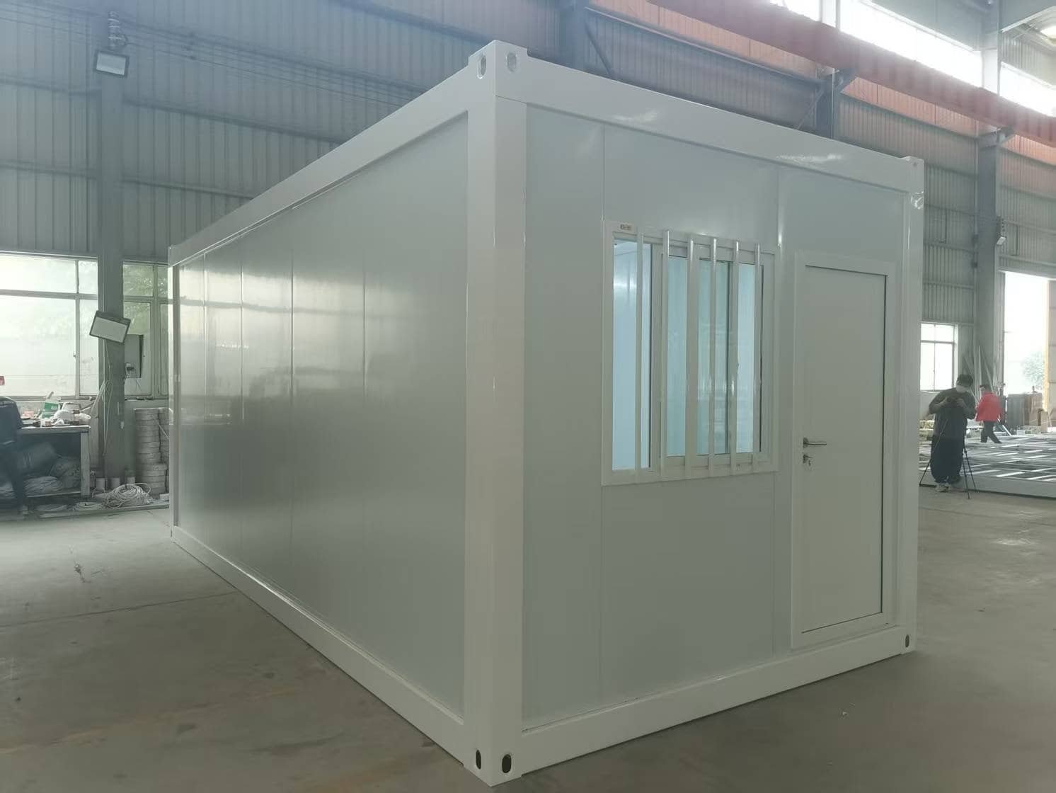 Portable modular house with insulated walls and windows, suitable for temporary or permanent habitation, manufactured for quick assembly and mobility in construction projects or remote locations.