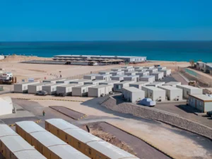 Premium Modular House coastal accommodation camp with rows of prefabricated modular units beside the sea.
