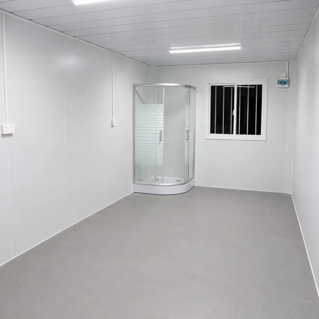 Premium Modular House flat pack container interior with a glass shower enclosure and barred window.