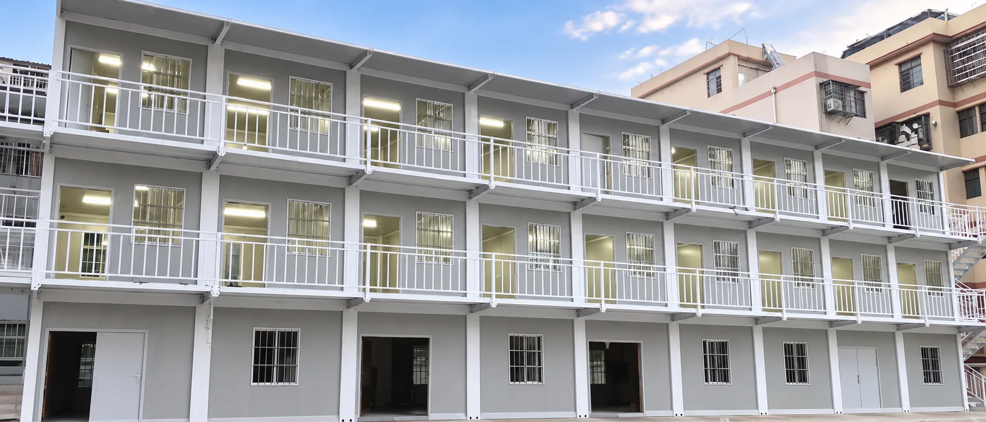 Completed multi-storey flat-pack accommodation building with exterior walkways, guardrails and covered access
