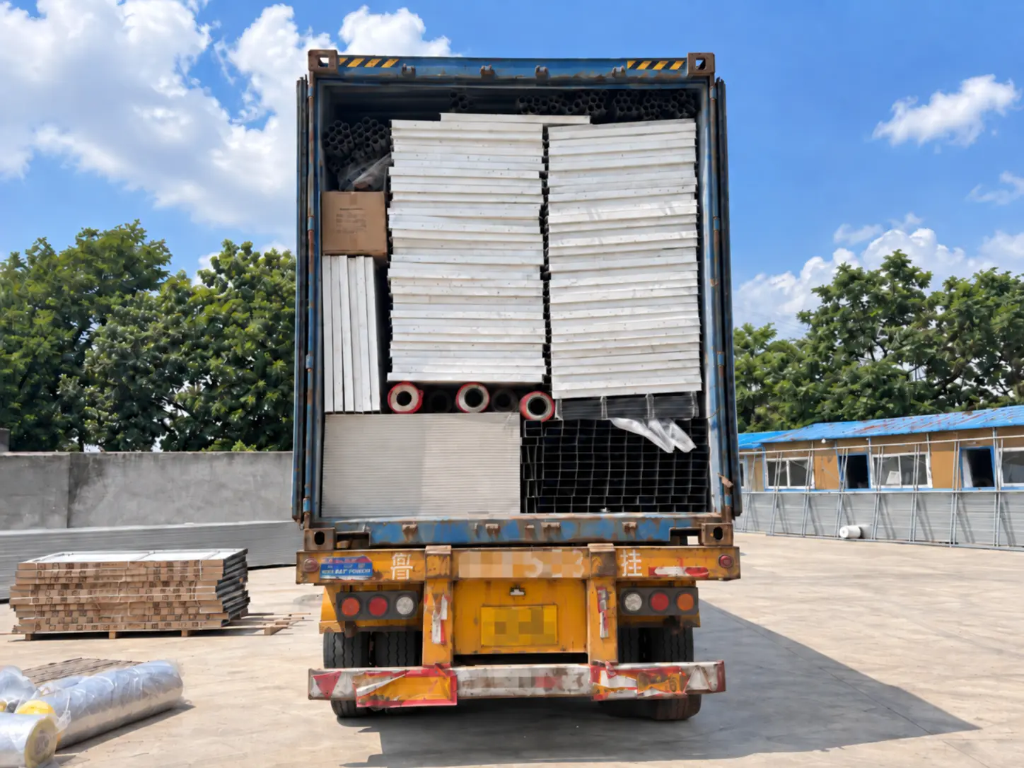 Detachable container house panels and structural components loaded inside an open delivery truck