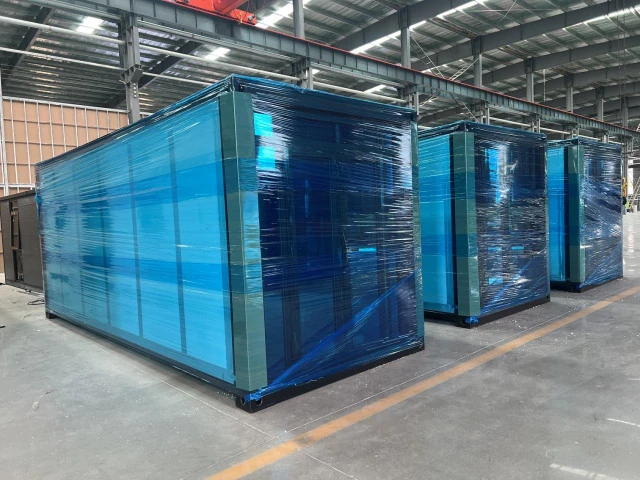 Folded expandable house protected with blue wrapping in the workshop