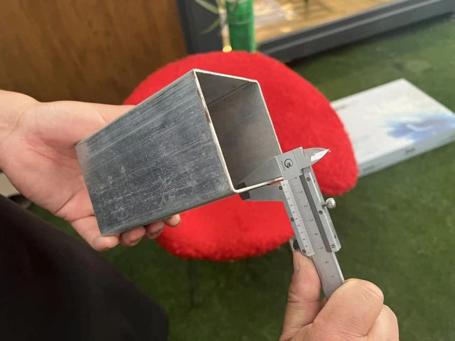 Steel frame section thickness being measured with a caliper