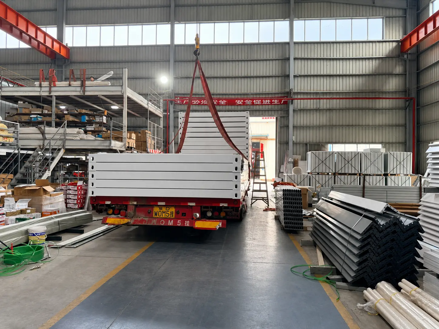 Flat-pack modular panels loaded onto a truck inside the premiummodularhouse factory.