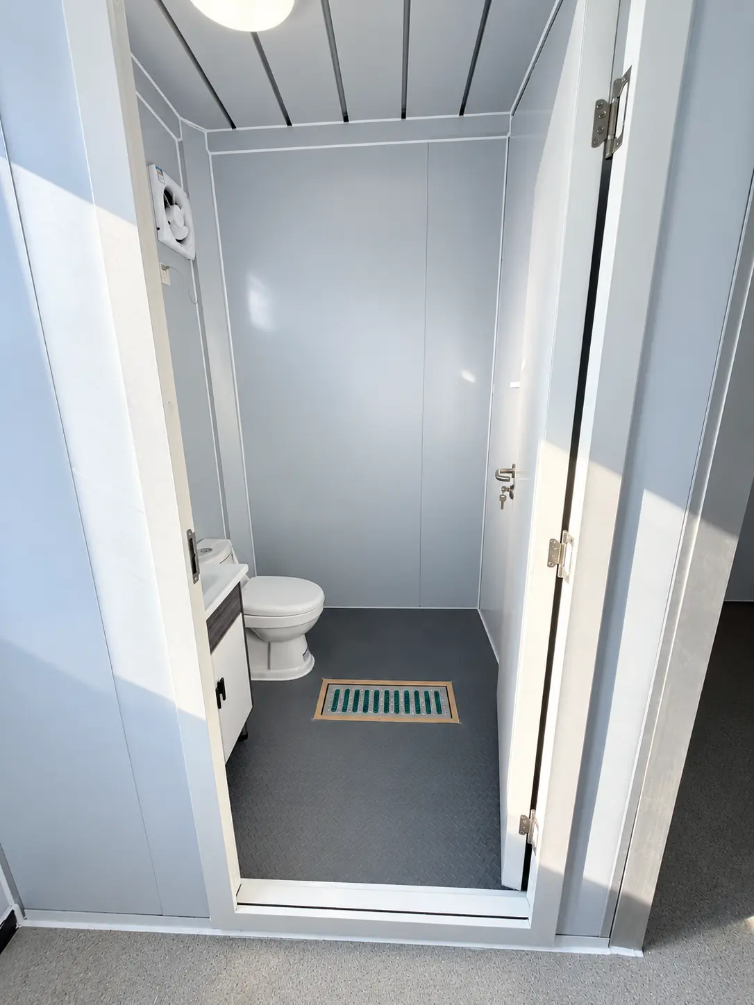 Factory-built modular bathroom interior with toilet, basin, ventilation and floor drain
