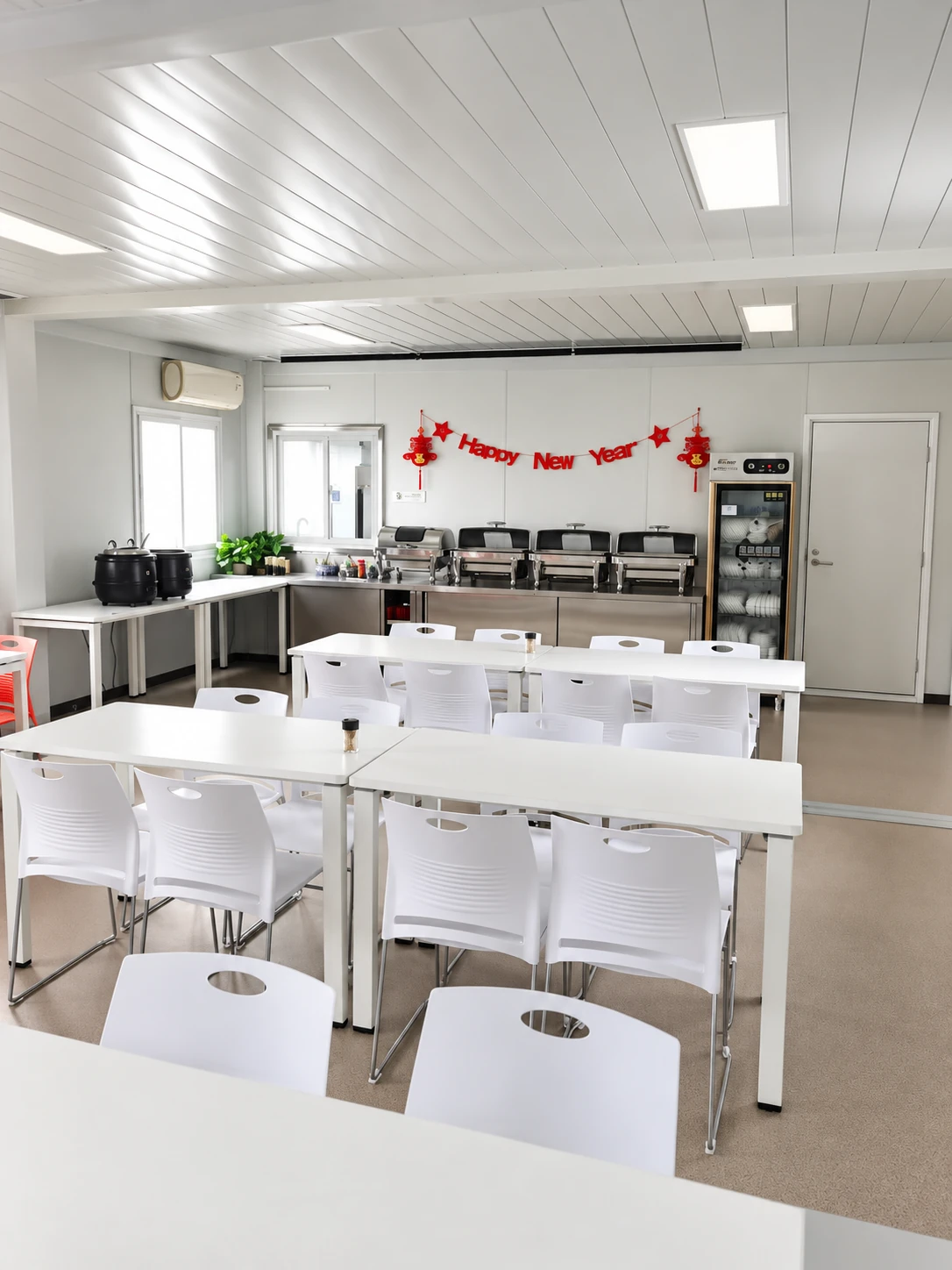 Compact staff dining area with shared tables and meal-serving equipment