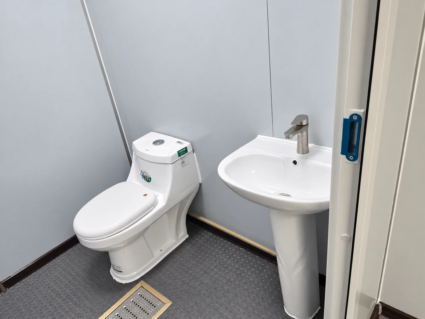 Compact sanitary interior with a WC, handwash basin and floor drain