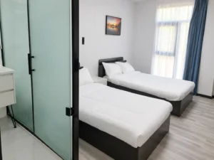 Twin-bed room configuration reference with an enclosed bathroom and window