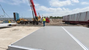 Flat-pack components, a delivery truck and a mobile crane at the Shantou camp site