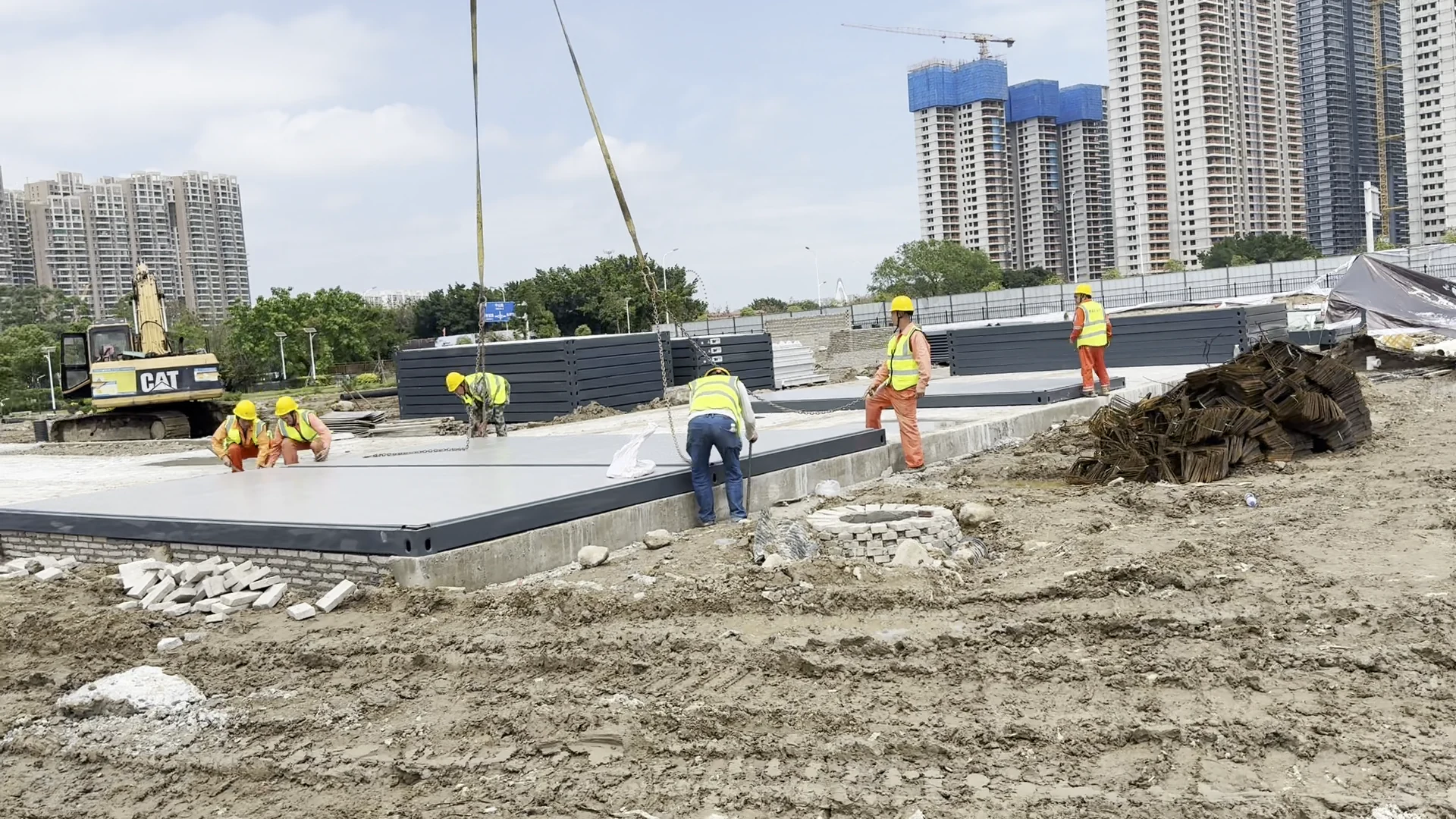 Grey flat-pack floor sections being positioned on prepared concrete supports
