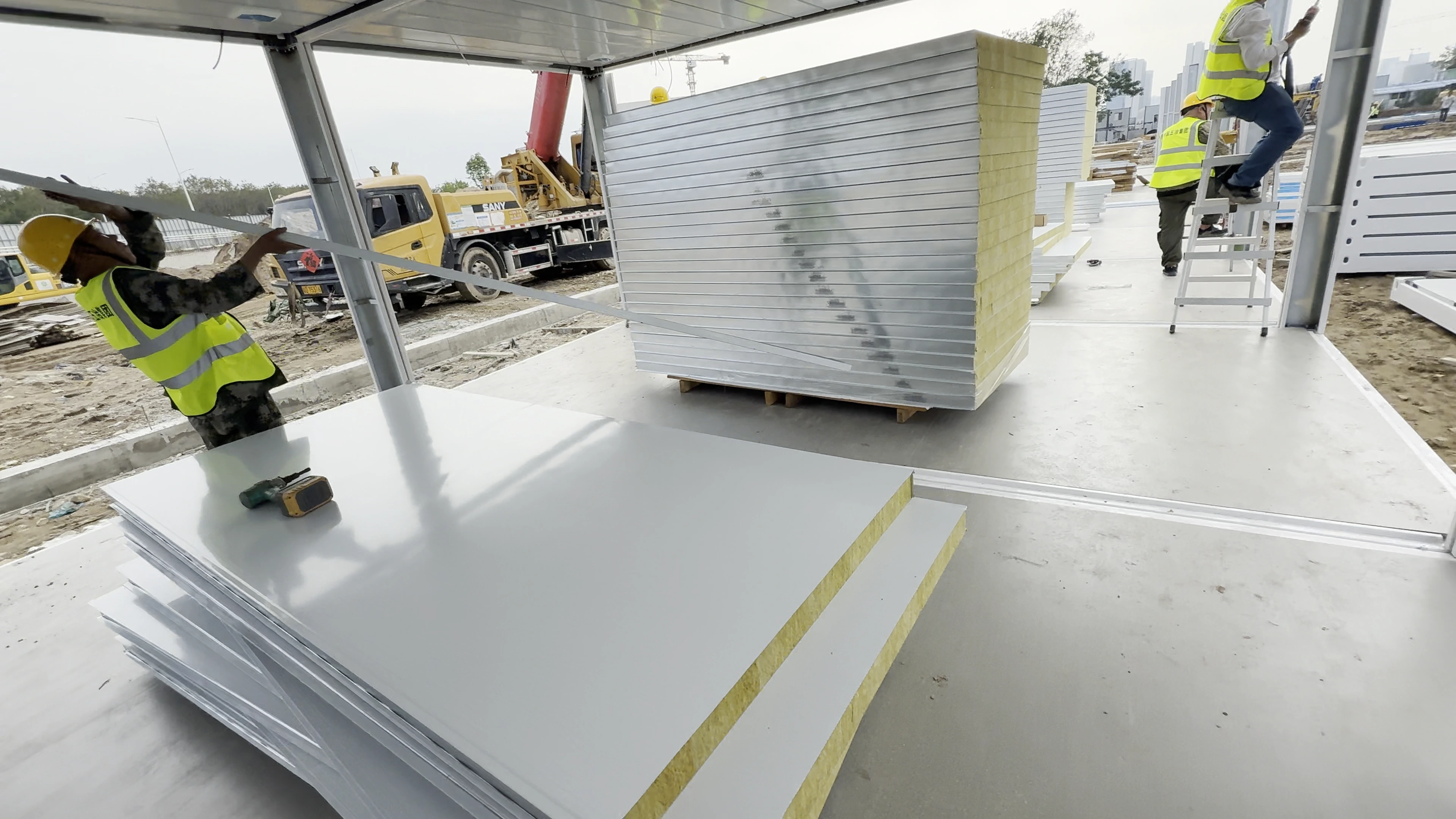 Wall-panel stacks and enclosure assembly inside a white flat-pack frame