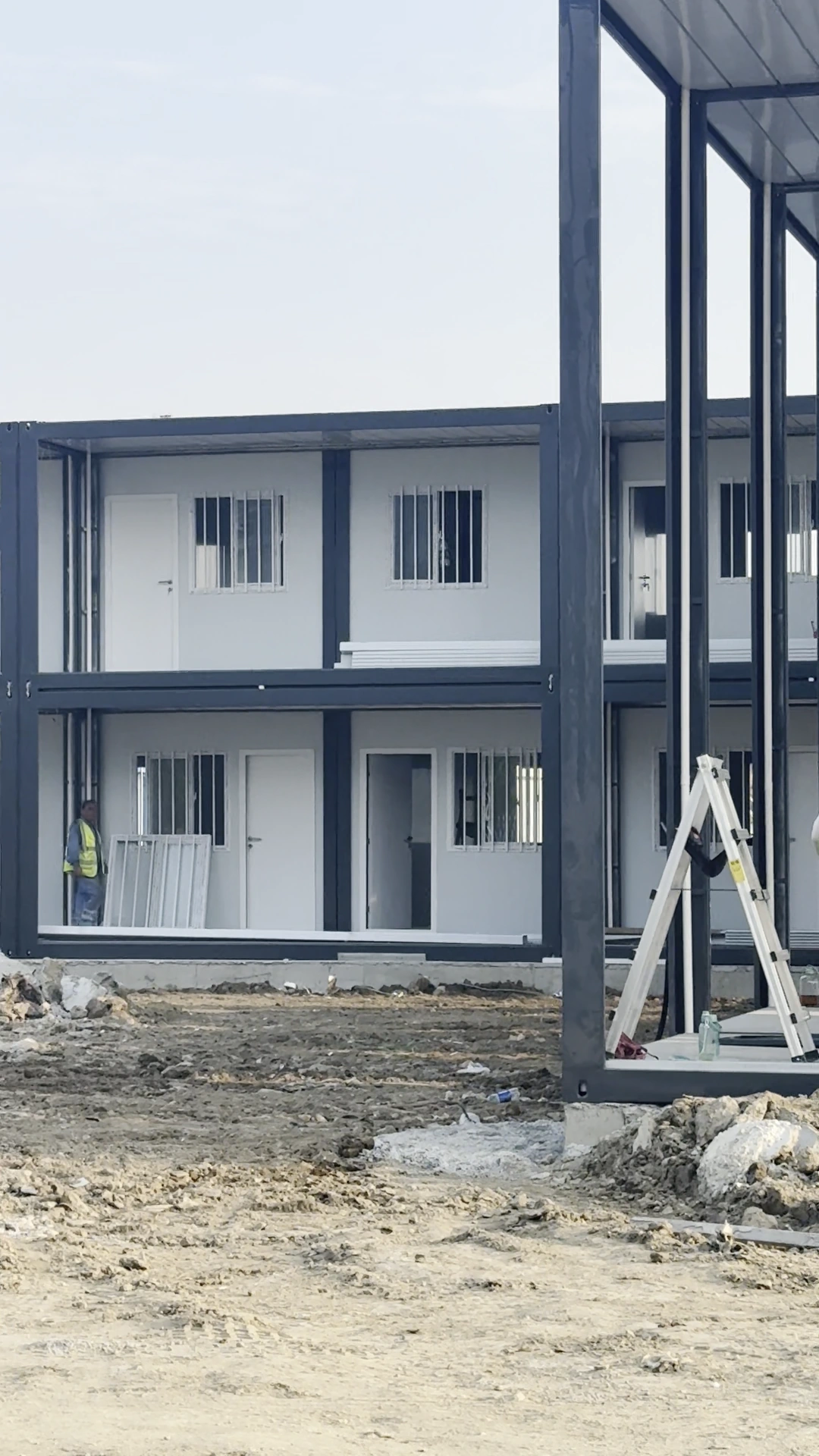 Two-storey grey-framed office block with doors and windows during assembly