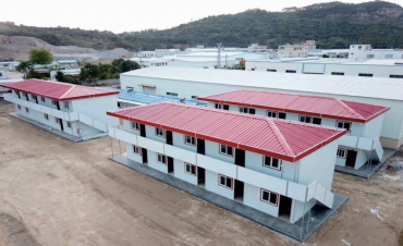 Dois edifícios T-House com telhados inclinados vermelhos e passadiços exteriores